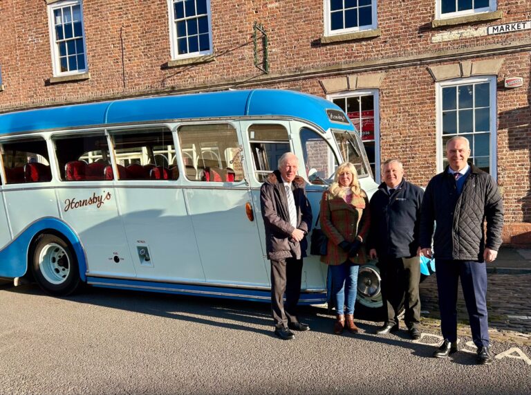 Cllr David Rose, Cllr Judy Kennedy, Robin from Hornsby's Travel and Cllr Tim Mitchell i front of Hornsby's vintage bus in Epworth Market Place